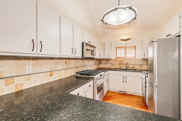 kitchen with decorative light fixtures, stainless steel appliances, and white cabinets