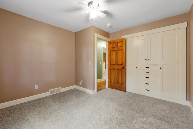 unfurnished bedroom with light carpet, ceiling fan, and a closet