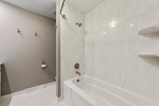 bathroom with tiled shower / bath combo and tile patterned floors