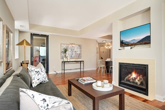 living room with a tray ceiling and hardwood / wood-style flooring