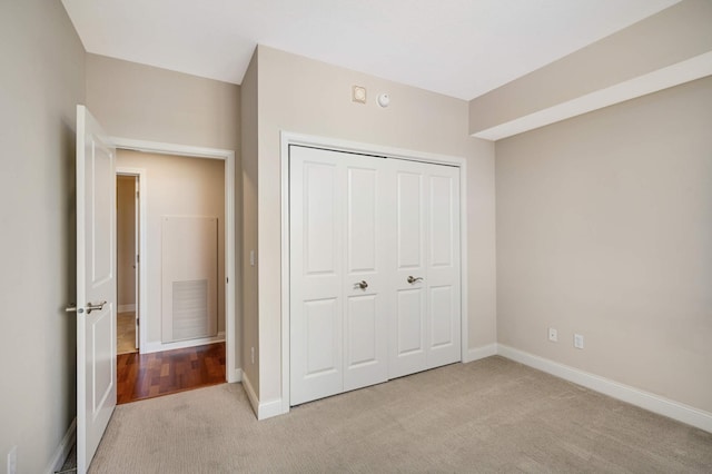 unfurnished bedroom featuring a closet and light colored carpet