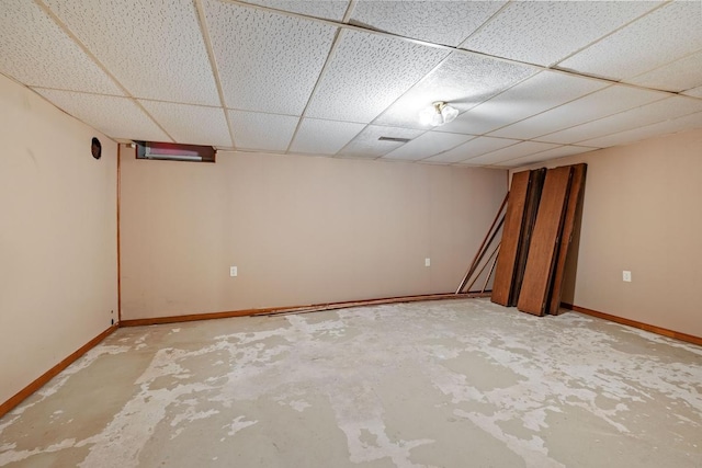 finished below grade area featuring a paneled ceiling and baseboards