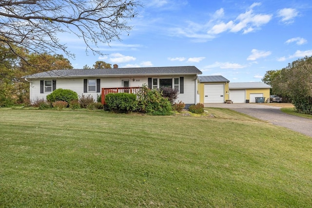 ranch-style house with a garage, an outbuilding, a deck, and a front lawn