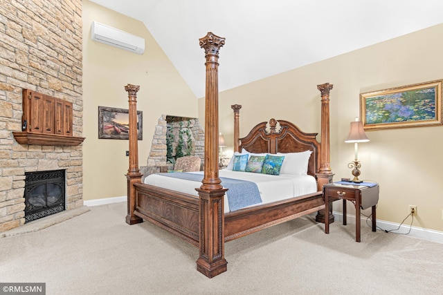 bedroom with light carpet, a stone fireplace, vaulted ceiling, and a wall unit AC