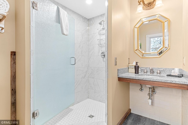 bathroom featuring wood-type flooring, a shower with shower door, and sink