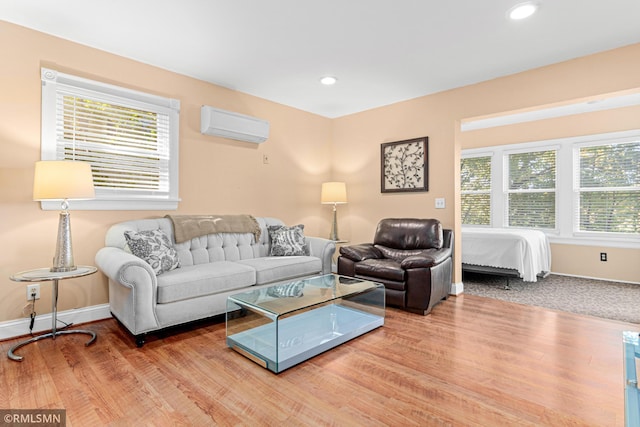 living room featuring a wealth of natural light, hardwood / wood-style flooring, and a wall mounted AC