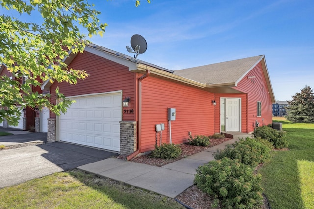 2136 Cleveland Ln S, Cambridge, MN 55008 - view of front facade featuring aphalt driveway, a garage, and a front lawn