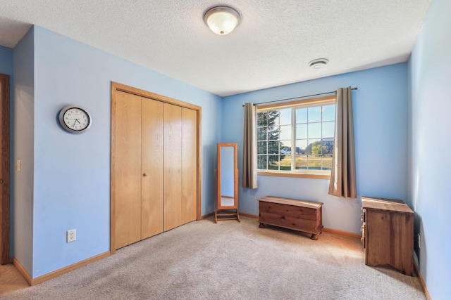 unfurnished bedroom with a textured ceiling, light colored carpet, and a closet