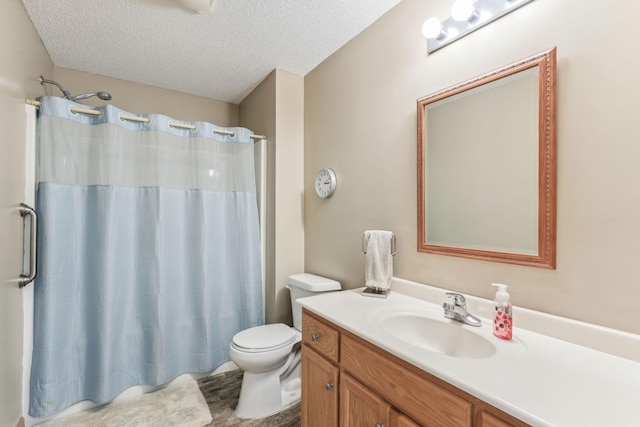 bathroom featuring a textured ceiling, vanity, and toilet