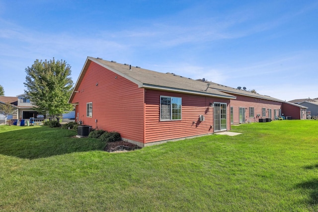 back of property with a lawn and central AC unit