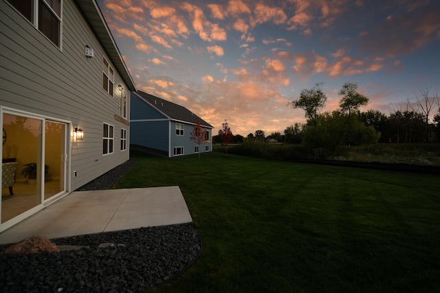 yard at dusk featuring a patio