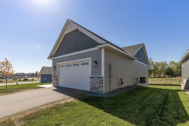 view of side of home featuring a garage, a yard, and central air condition unit