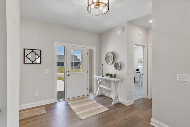 foyer with a notable chandelier, dark hardwood / wood-style floors, and a textured ceiling