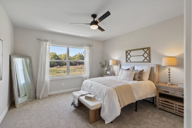 carpeted bedroom with ceiling fan and a textured ceiling