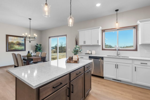 kitchen with white cabinetry, pendant lighting, sink, and stainless steel dishwasher