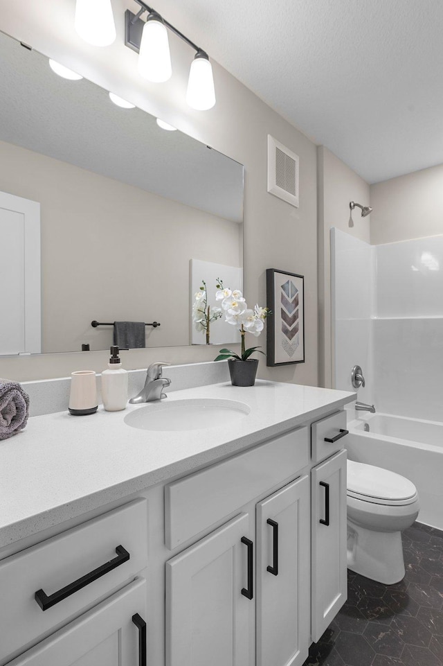 full bathroom with shower / washtub combination, vanity, a textured ceiling, and toilet