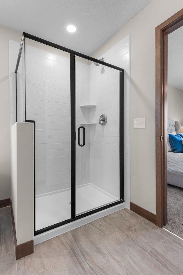 bathroom featuring a shower with door and a textured ceiling