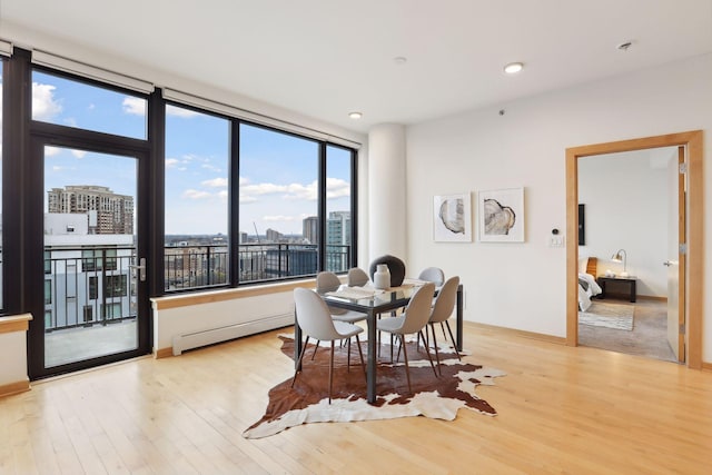 dining space featuring light hardwood / wood-style flooring and a baseboard heating unit