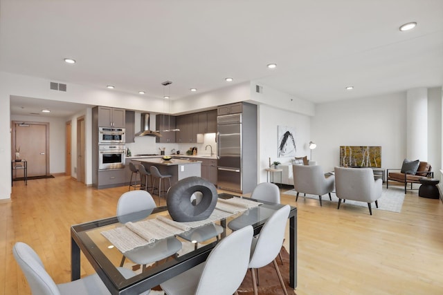 dining space featuring light hardwood / wood-style flooring and sink