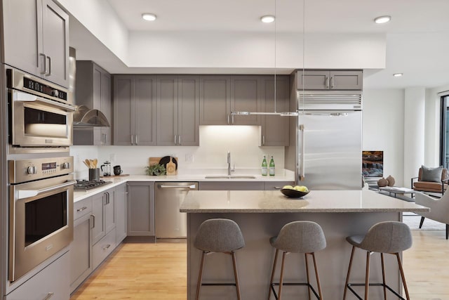 kitchen featuring a center island, sink, light wood-type flooring, and stainless steel appliances