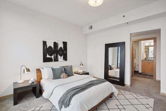 carpeted bedroom featuring ensuite bath