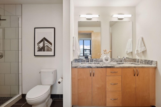 bathroom featuring tile patterned floors, vanity, toilet, and tiled shower