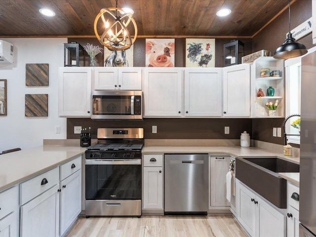 kitchen featuring hanging light fixtures, stainless steel appliances, and white cabinets