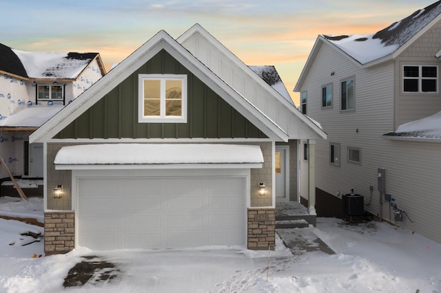 view of front of property featuring a garage and cooling unit