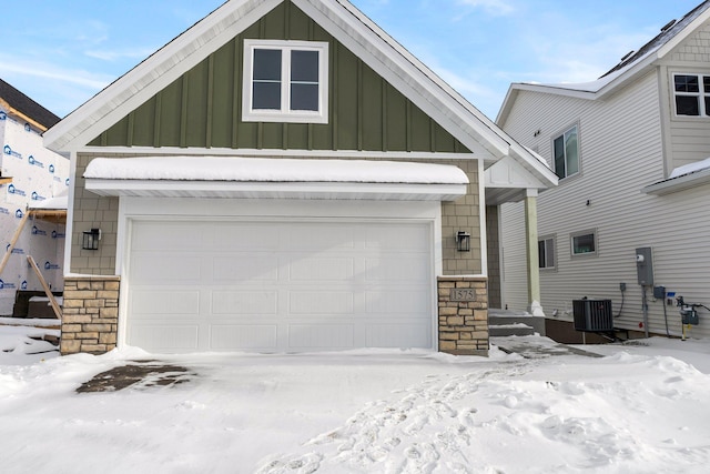 view of front of home with a garage and central AC