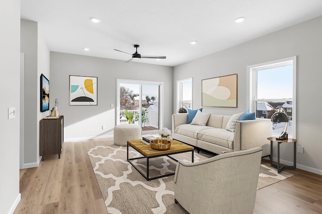 living room with light hardwood / wood-style floors and ceiling fan