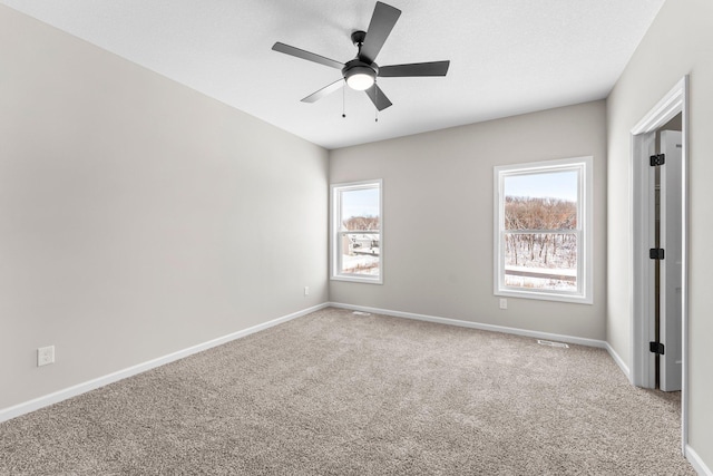 carpeted spare room with ceiling fan