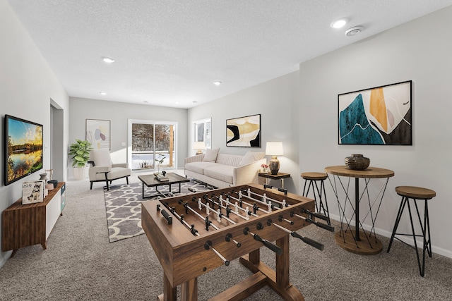 playroom featuring carpet flooring and a textured ceiling