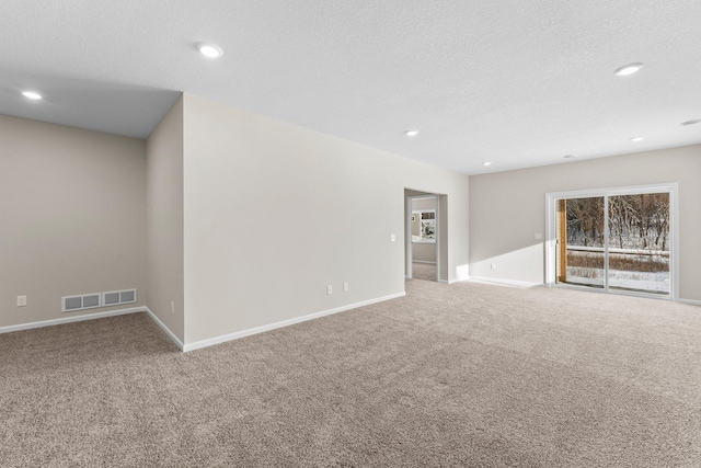 spare room with carpet flooring and a textured ceiling