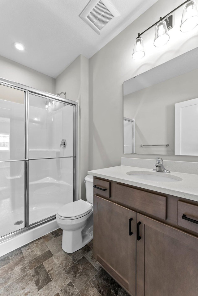 bathroom featuring vanity, toilet, and walk in shower