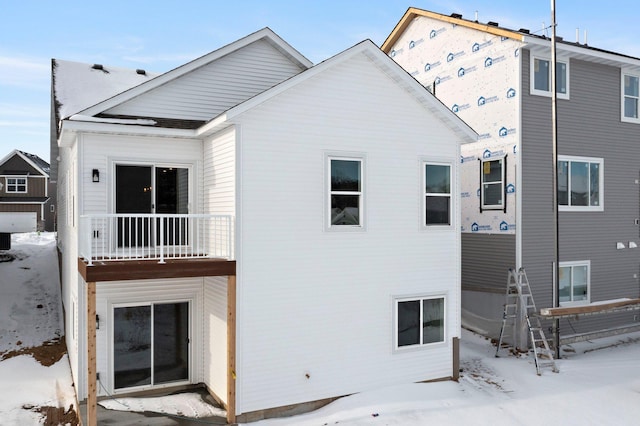 view of snow covered back of property