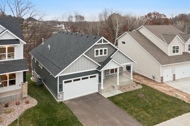 craftsman inspired home featuring a front yard, a garage, and cooling unit