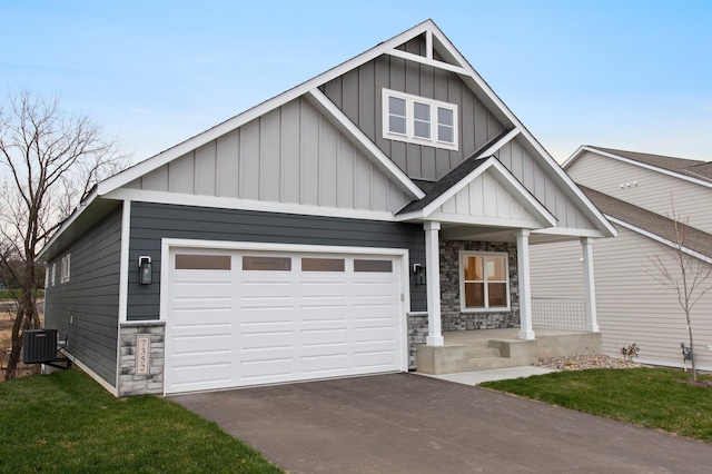 craftsman-style house with central AC, a front lawn, and a garage