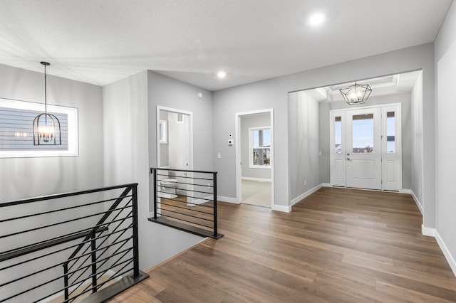 foyer with dark hardwood / wood-style floors, a textured ceiling, and a chandelier