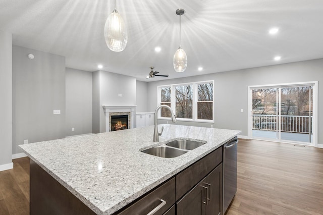 kitchen featuring dark wood-type flooring, sink, a healthy amount of sunlight, and a center island with sink