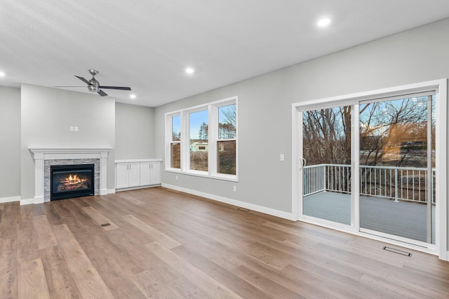 unfurnished living room featuring ceiling fan and light wood-type flooring