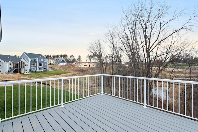 deck at dusk featuring a yard