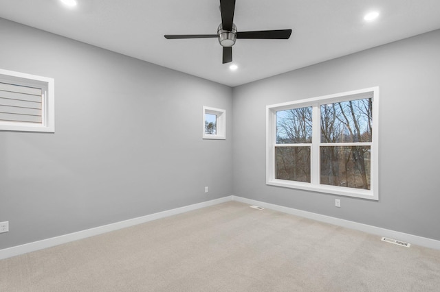 spare room featuring ceiling fan and light colored carpet