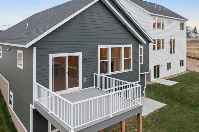 rear view of property featuring a yard and a deck