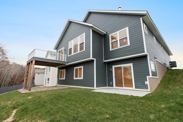 rear view of property featuring a yard, a patio area, and a balcony