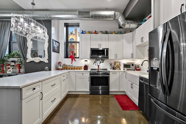 kitchen with tasteful backsplash, white cabinets, kitchen peninsula, stainless steel appliances, and decorative light fixtures