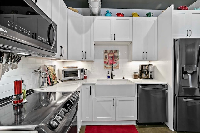 kitchen with decorative backsplash, white cabinetry, sink, and stainless steel appliances