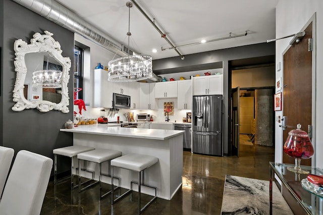 kitchen with hanging light fixtures, kitchen peninsula, white cabinetry, appliances with stainless steel finishes, and a kitchen bar