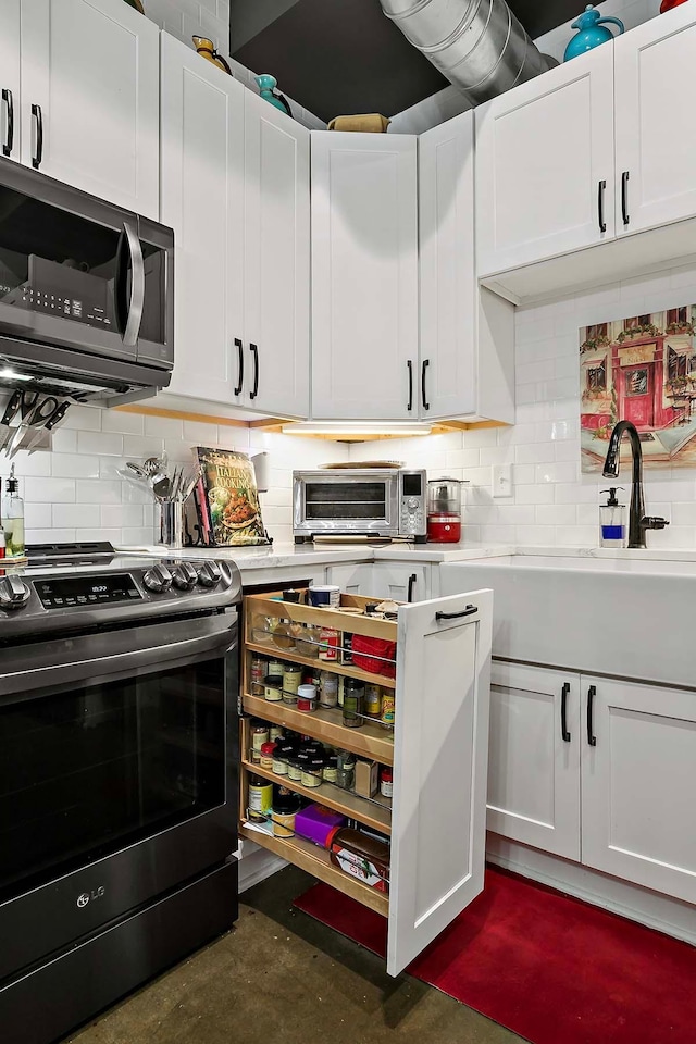 kitchen with white cabinetry, appliances with stainless steel finishes, and tasteful backsplash