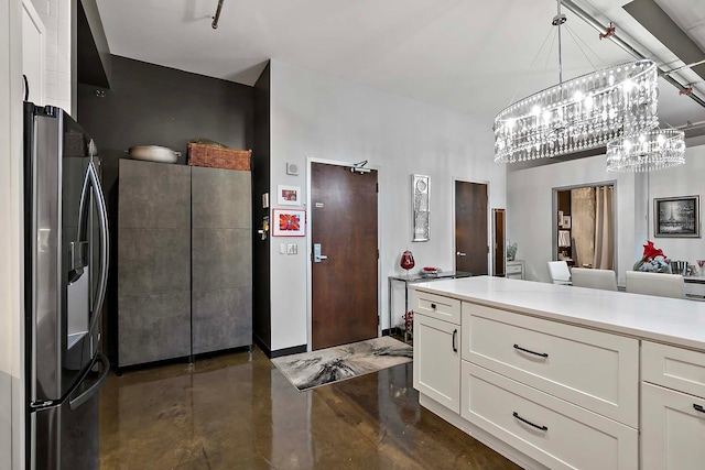 kitchen featuring stainless steel refrigerator with ice dispenser, white cabinetry, and hanging light fixtures