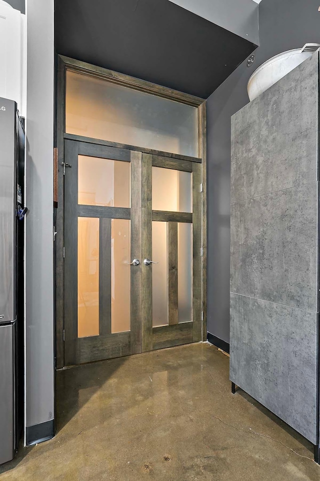 interior space featuring french doors and concrete floors